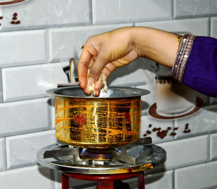 Indian family performing housewarming milk boiling ritual for prosperity Indian family performing housewarming milk boiling ritual for prosperity