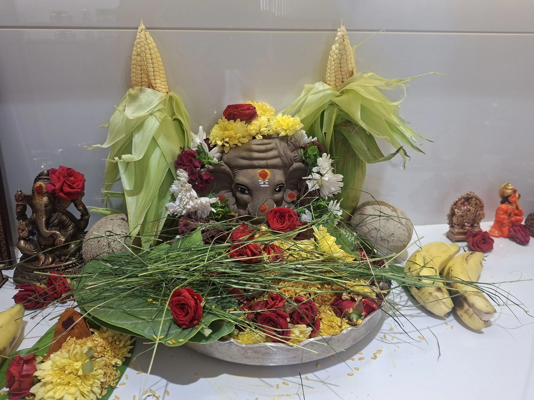 Simple clay Ganesha idol decorated with flowers at home during Ganesh Chaturthi