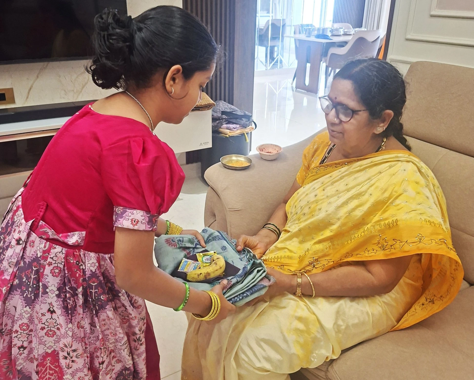 Girl offering tamboolam to an elder woman during Navratri celebrations. Offering Tamboolam to Mother